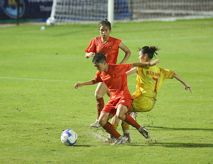 U19 nữ Việt Nam thử sức dưới mặt sân ướt do mưa lớn trước trận - Ảnh: Đình Viên
