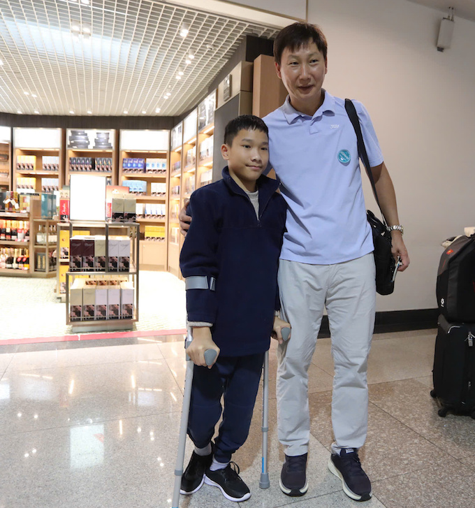 HLV Kim Sang Sik chụp ảnh với một khán giả nhí Indonesia. Ảnh: Anh Khoa