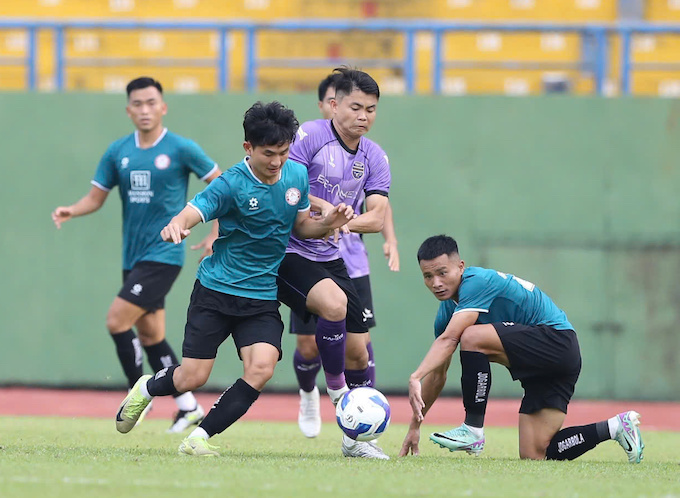 Tùng Quốc (Becamex TP.HCM) trong vòng vây của các cầu thủ CA TP.HCM. Ảnh: Hoàng Tùng 