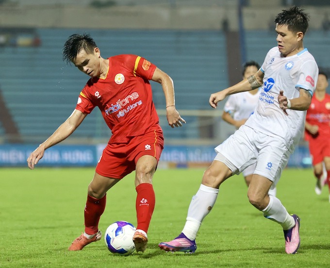 Trung Phong (áo đó, PVF-CAND) tranh bóng với Thanh Hào (Nam Định), Ảnh: Minh Tuấn