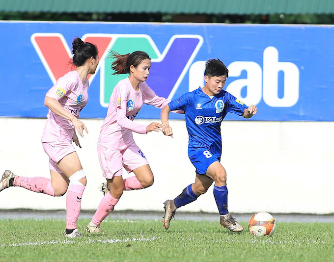 Các cầu thủ Hà Nội đeo bám Ngọc Minh Chuyên của Thái Nguyên (áo xanh). Phan Tùng