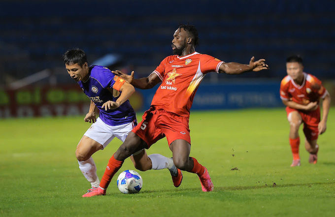 Pha tranh bóng của Hùng Dũng và ngoại binh của Hà Tĩnh. Ảnh: Đức Cường