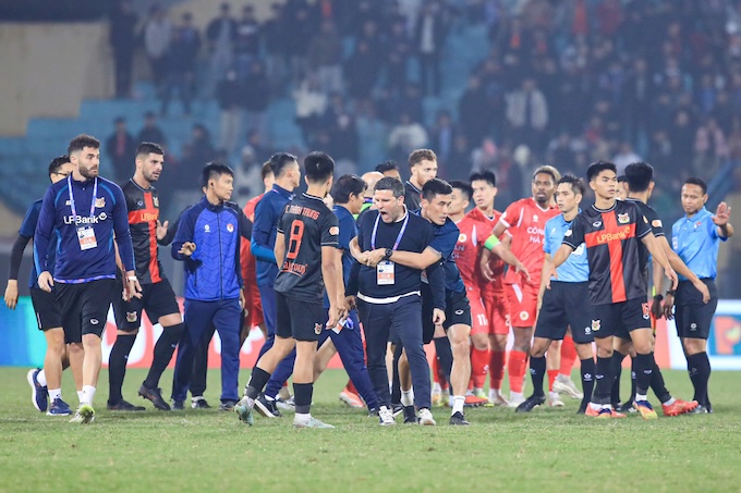 Các trợ lý phải kéo vị HLV của Ninh Bình ra khi ông này phản ứng dự dội với trọng T sau trận đấu. Ảnh: Minh Tuấn