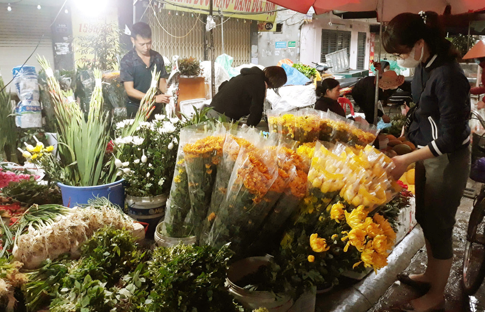 Người tiêu dùng mua hoa tươi dịp Rằm tháng Giêng tại chợ truyền thống. Ảnh: Hoài Na